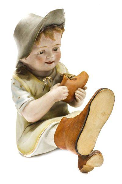 FIGURA EN BISCUIT PRINCIPIOS DEL SIGLO XX. "NIÑO CON ZAPATO"